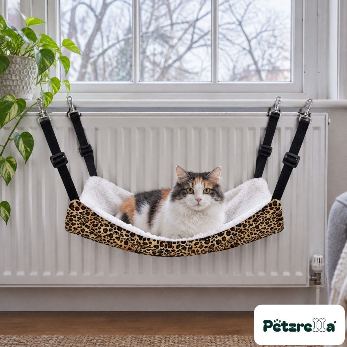 Petzrella Pet Cage Hammock clipped to a radiator with a calico cat