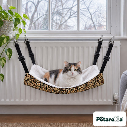 Petzrella Pet Cage Hammock clipped to a radiator with a calico cat