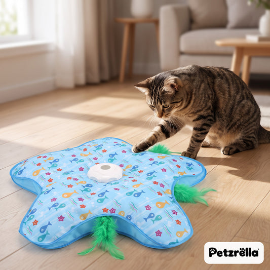 Petzrella hide-and-seek cat toy in blue fish print with a tabby cat pouncing on the feather at home