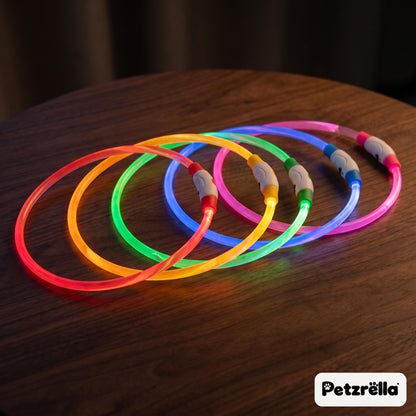 Petzrella USB rechargeable LED pet collars glowing in five colours on a wooden table