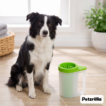 Petzrella green portable paw cleaner cup next to a border collie on a wooden floor