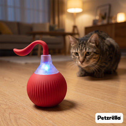 Petzrella smart rolling cat ball with red magic tail glowing blue on a wooden floor, cat watching