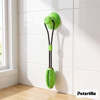 Petzrella suction tug toy in fruit green with chew stick stuck to a kitchen tile wall