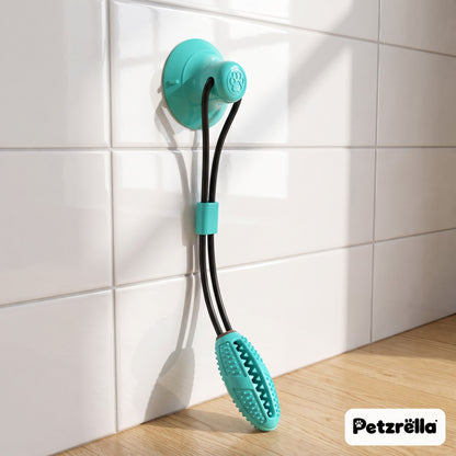 Petzrella suction tug toy in lake blue with chew stick stuck to a kitchen tile wall