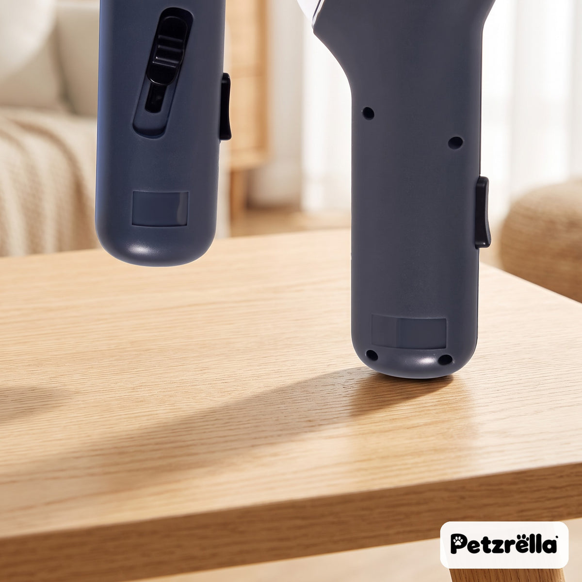 Petzrella interactive treat launcher close-up of the dark grey body and switch on a wooden table